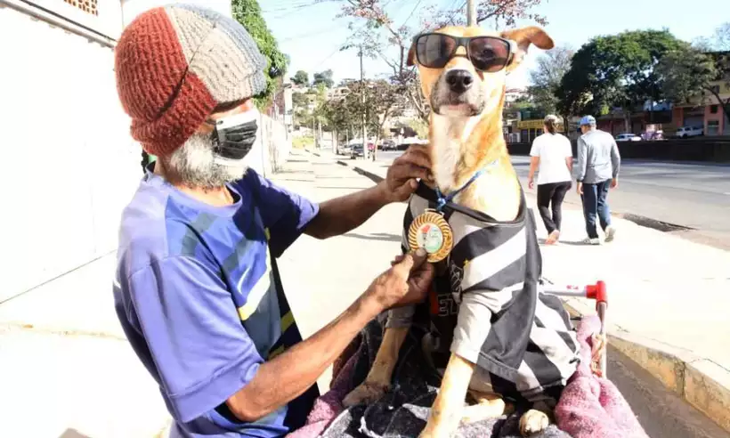 Homem em situação de rua protege cão do frio com camisa do Atlético